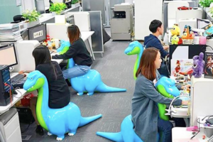 Workers sitting on dinosaur chairs